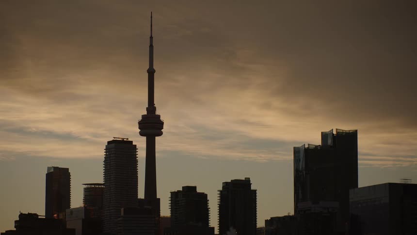 The cn tower and toronto city skyline in silhouette at dawn
