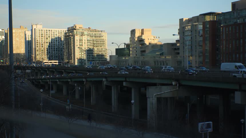 Heavy traffic moves across bridges going in and out of downtown with tall buildings in the distance