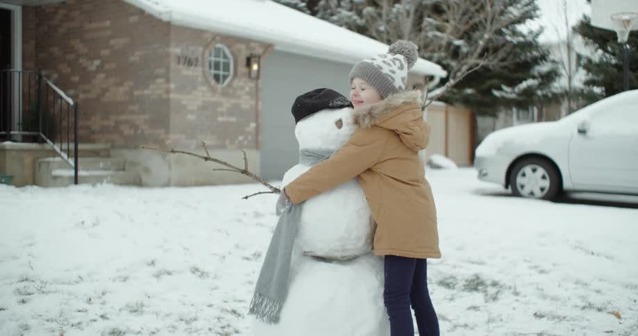 A child hugs the snowman