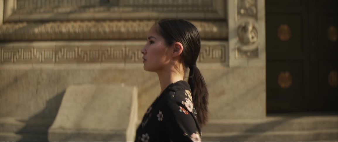 A woman walks past buildings downtown