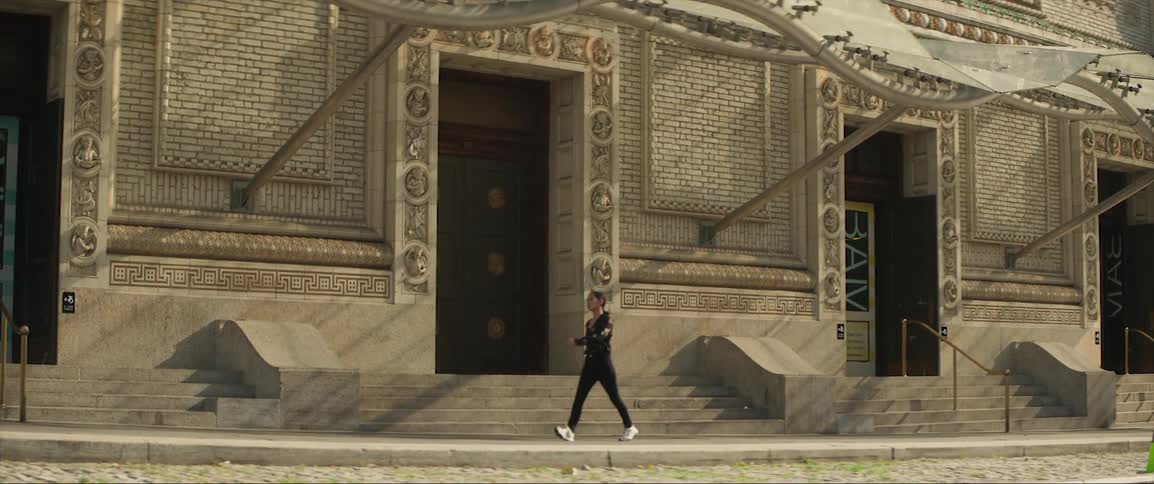 A woman walks past a historical ornate building