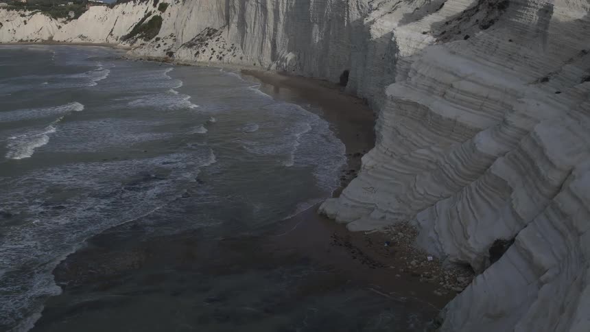 Waves come ashore near white cliffs