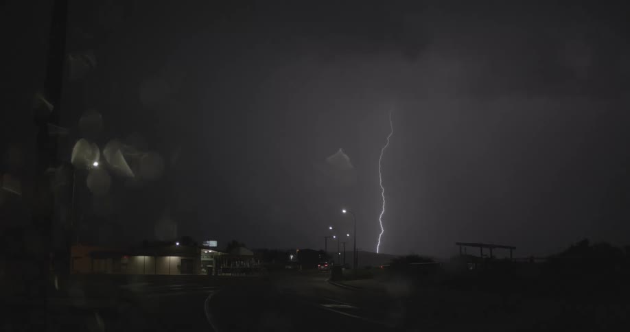 Lightning flashing in a dark night sky during a rainstorm