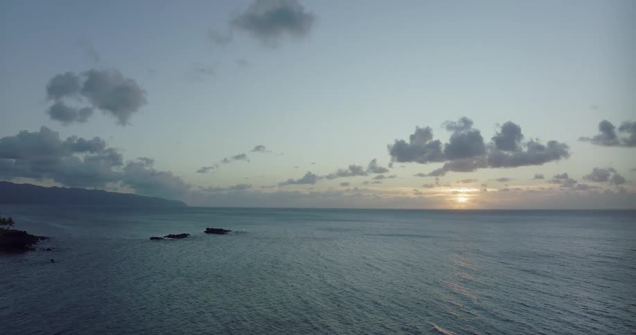 The sun is setting in the horizon of the ocean