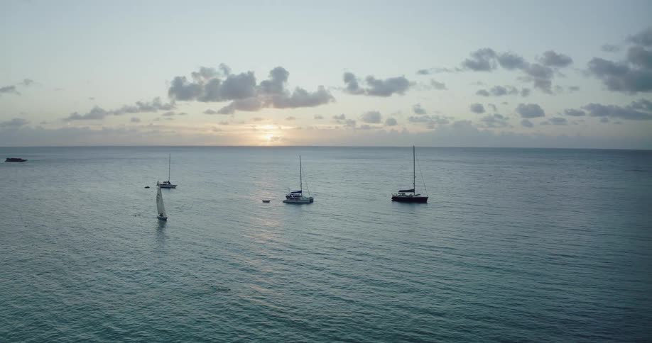 Boats are driving on ocean water during sunset
