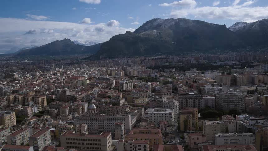 A coastal city has many buildings by a mountain