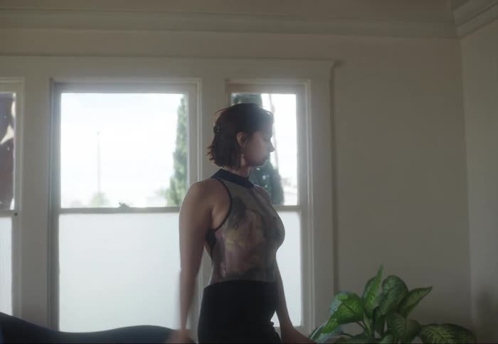 A woman is dancing and moving her arms in the air and above her head
