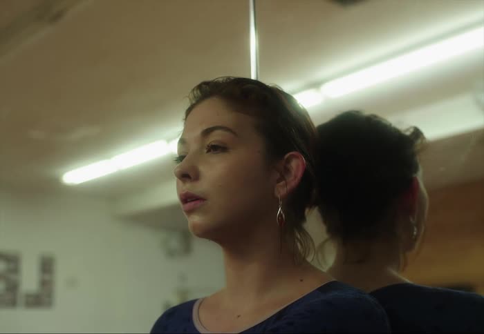 A woman relaxes against the mirror