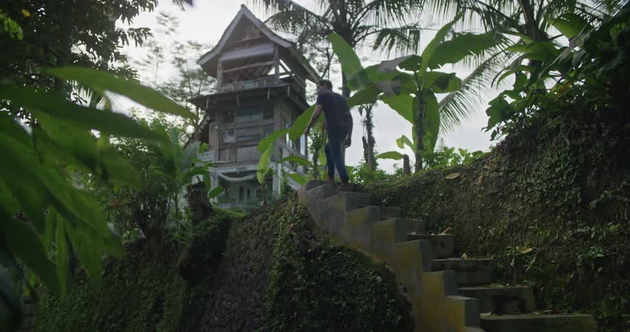 Man climbs up the stairs in the tropical countryside
