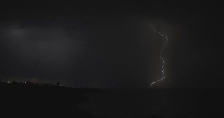 Thunder and lightning flash through the thick clouds at night