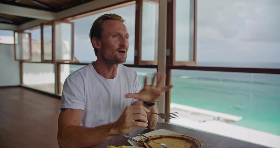 A man is shown a camera while he eats