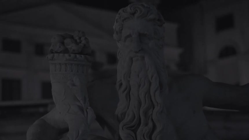 A stone statue is in the shape of a man with a beard