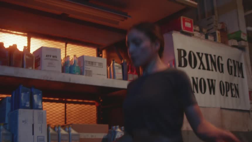 Young woman jumping rope in the back of a boxing gym