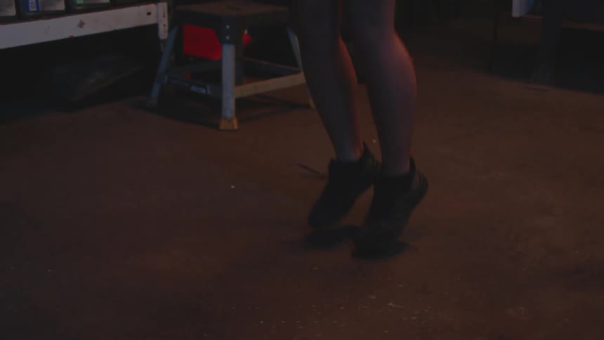 Young woman jumping rope on the back of a boxing gym