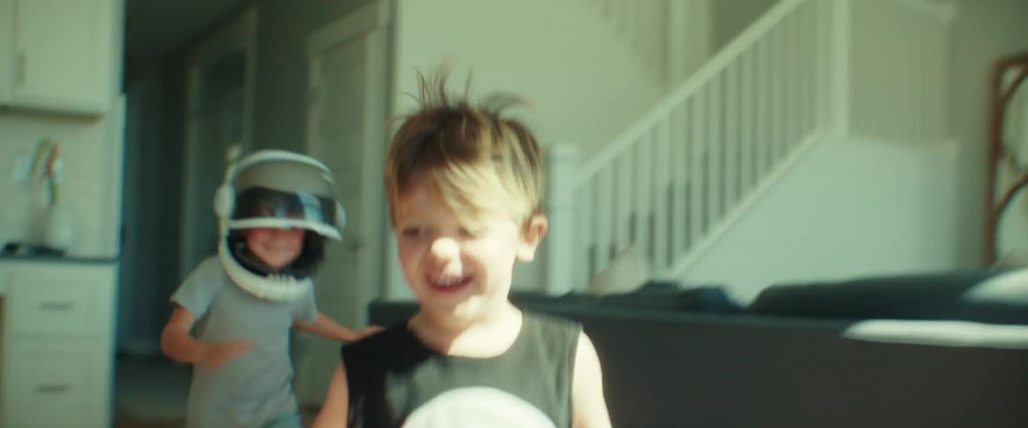 Happy brothers running around the living room at home