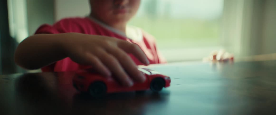 A child is playing with a toy car