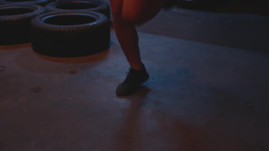 Woman jumps rope in commercial garage with garage door open at night