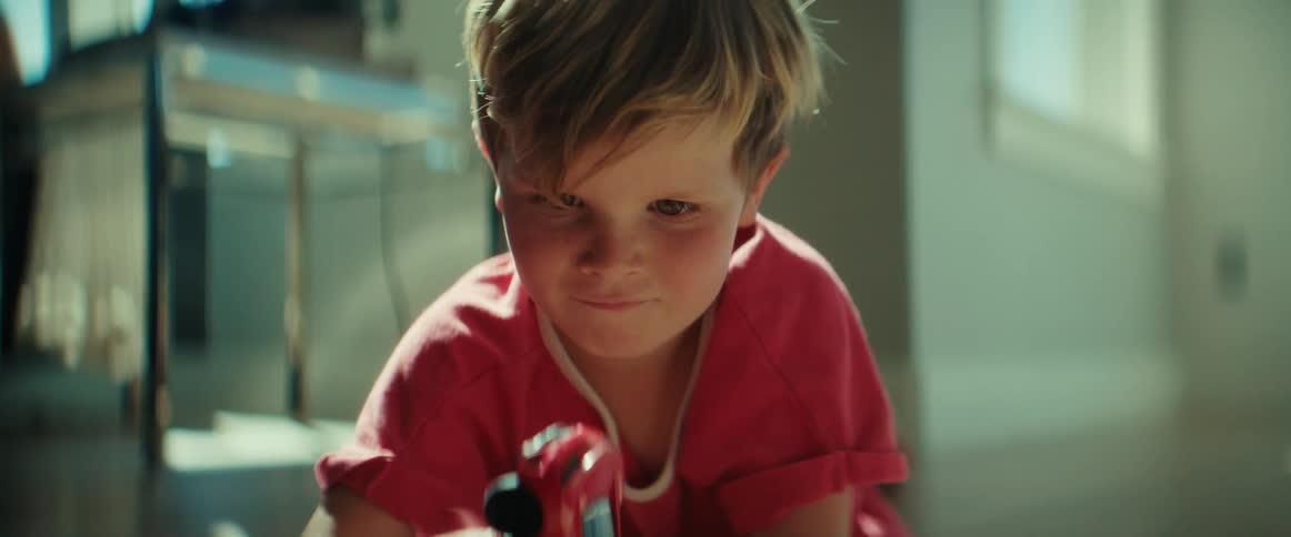 A child is playing with a toy car