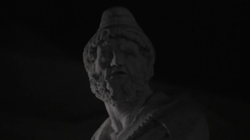 A stone statue of a man wearing a hat