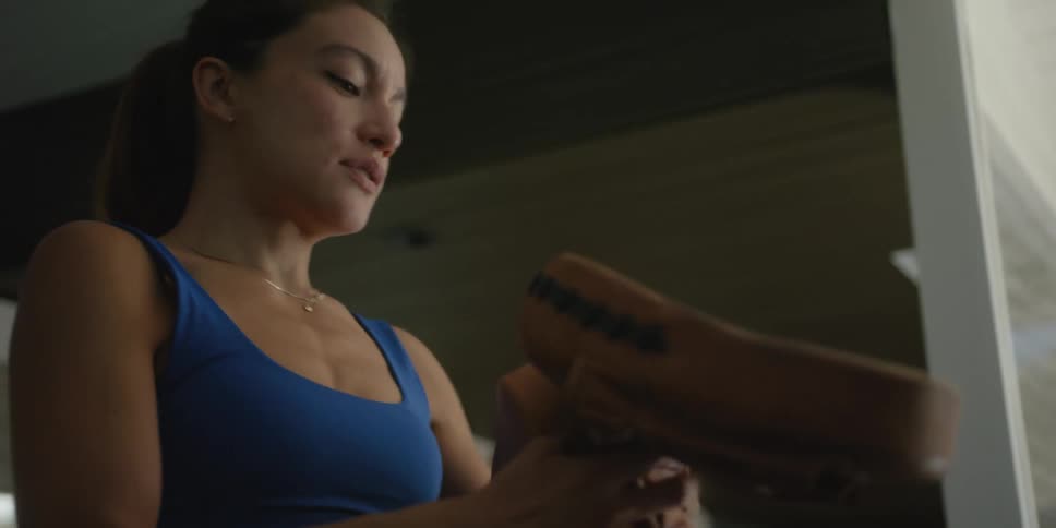 A woman puts on a pair of punch mitts