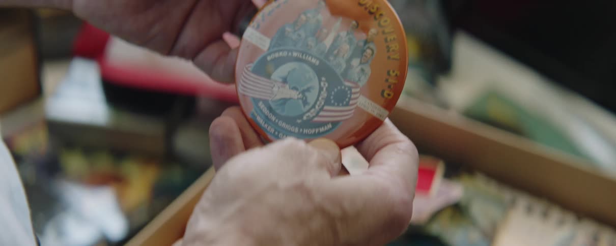 A man picks a badge up out of a drawer