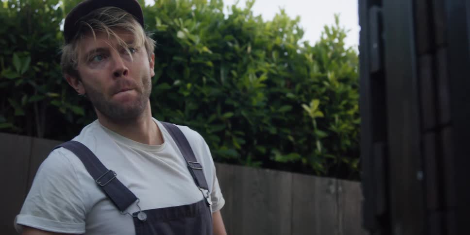 A man shakes his head in the yard