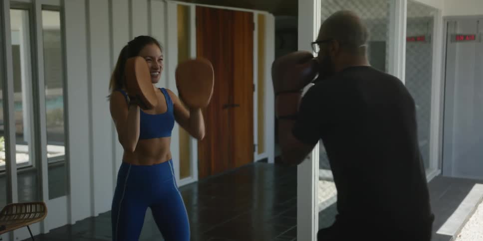 Man sparring with a female boxing trainer on the backyard at daytime