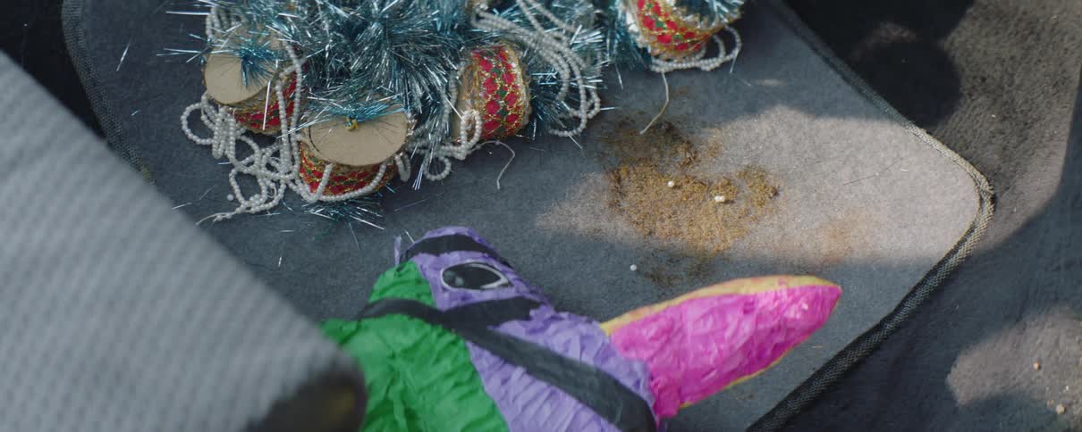A portion of a pinata and party favors rest on the ground