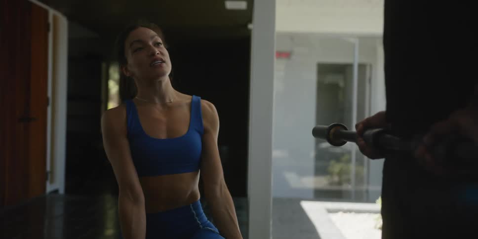 A personal trainer helps a client lift weights