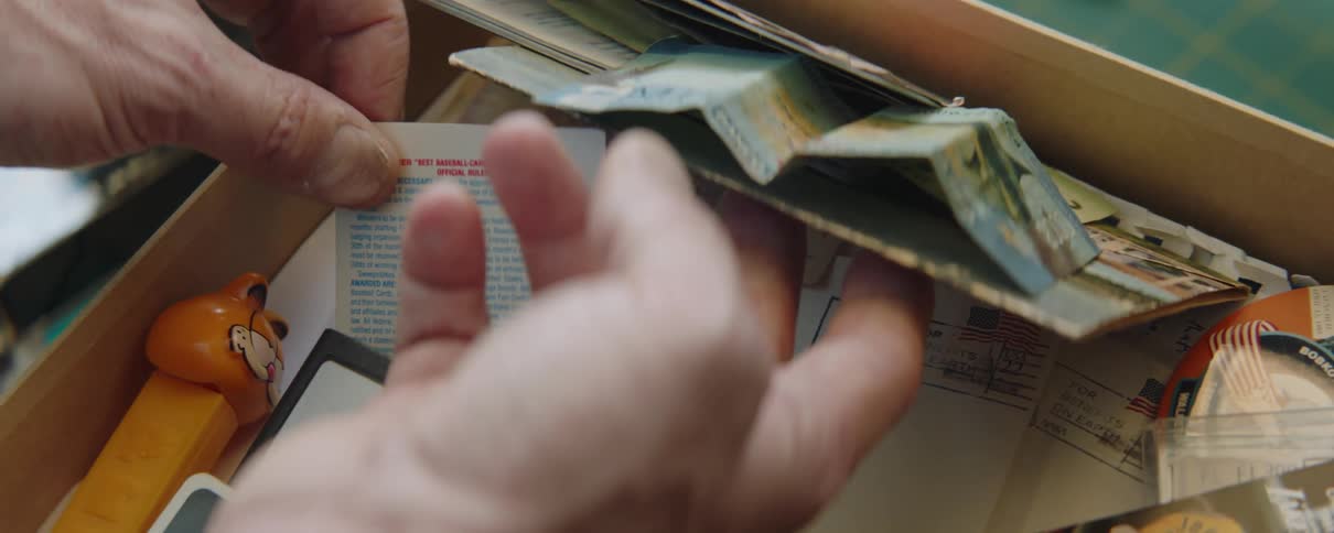 Man rummaging on a drawer filled with vintage items picks up a coupon