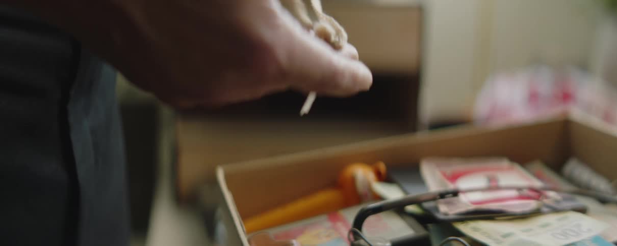 Man stands looking through small drawer of keepsakes