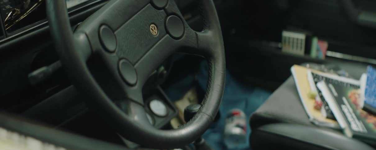 The inside of a vehicle is scattered with trash and papers
