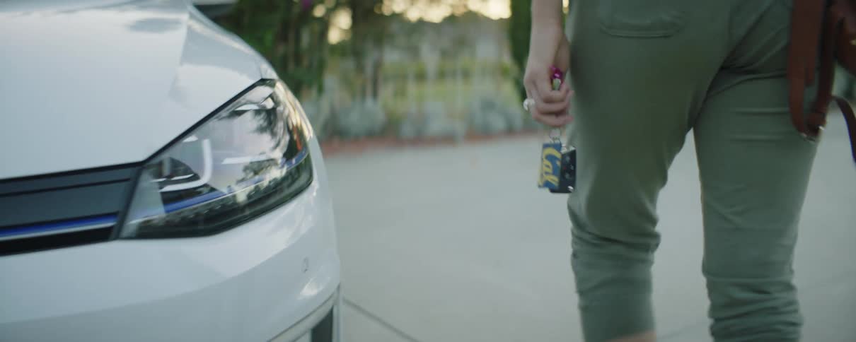 A woman holds her keys while walking to her vehicle