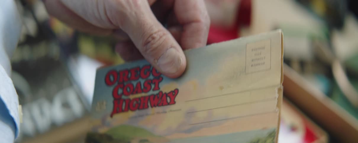 Man examines postcards and replaces them in keepsake box