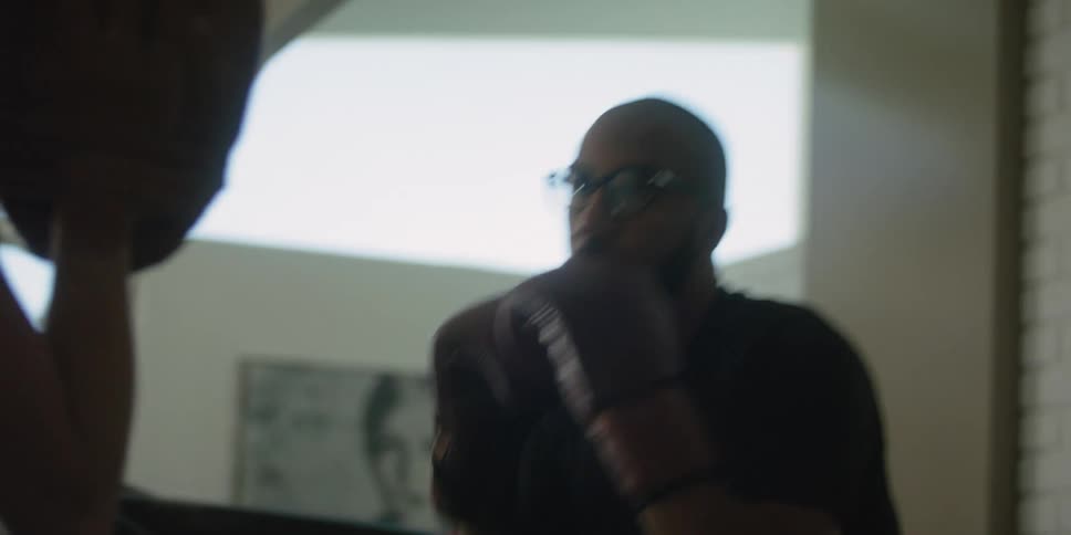 A personal trainer boxes with a client in the gym