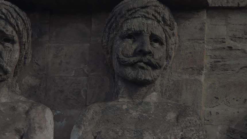 A wall decorated with carved faces