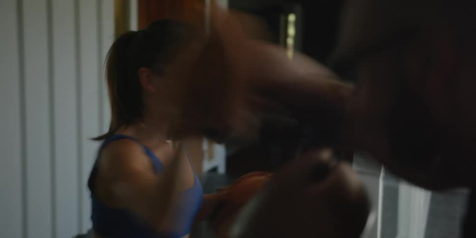 Female fitness instructor guides man through boxing training