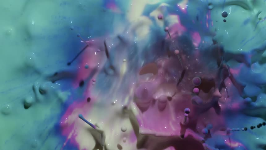 Close up of a splashing multicolored liquid ink sending droplets flying in the air