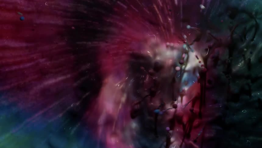 Colorful paints drop into water and blend together