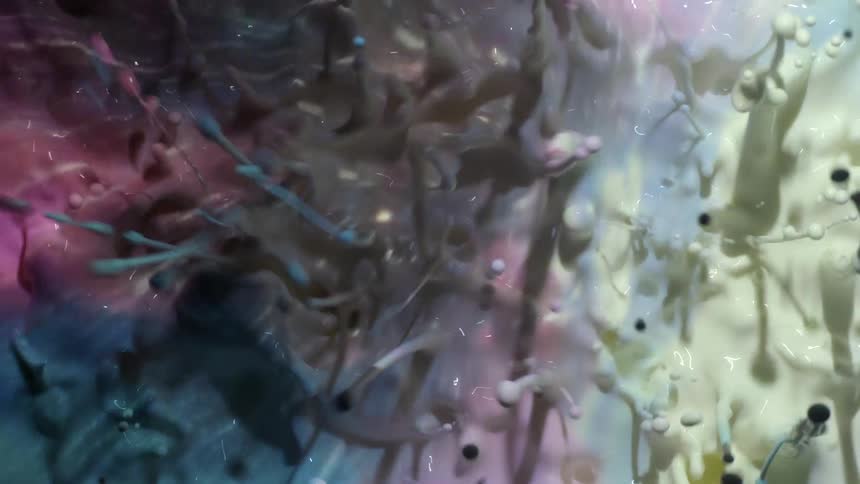 Multicolored projection on a white splashing liquid sending droplets in the air