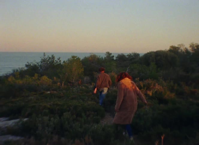 Man and woman are hiking outdoors during sunset