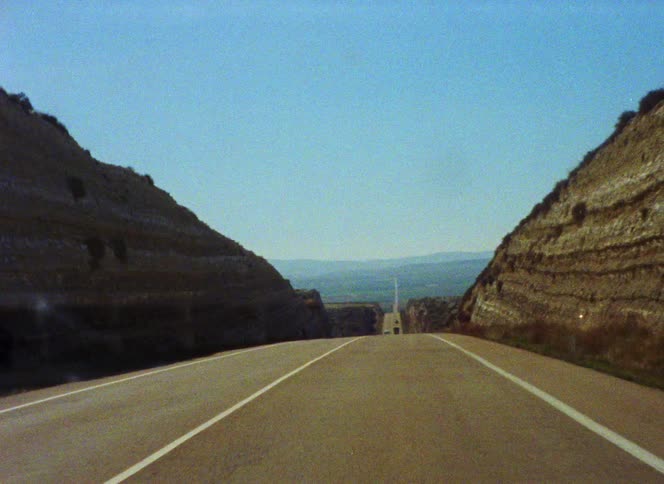 Traffic moves along highway through hilly countryside