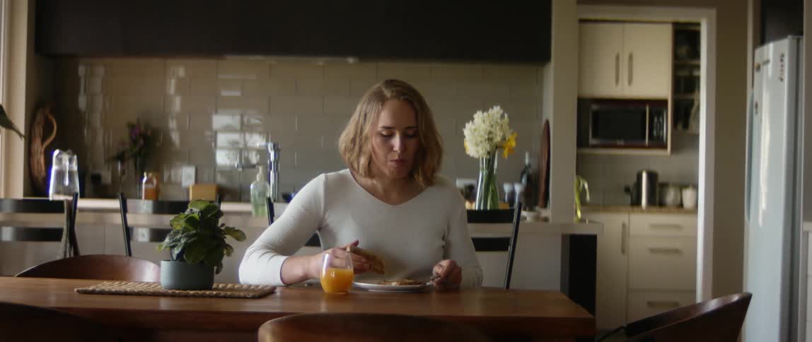A woman eating toast at a table