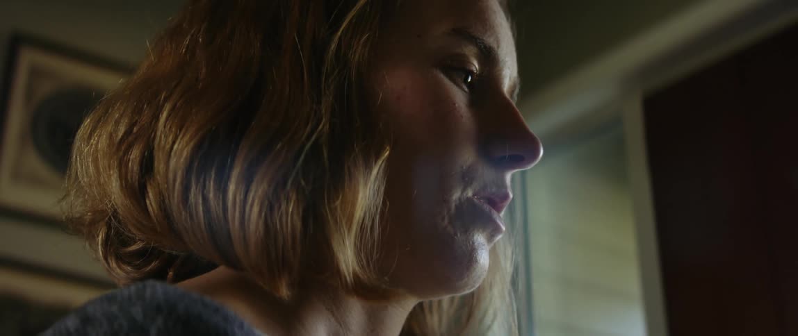Light shines on the face of a teenage girl who appears to be in deep thought