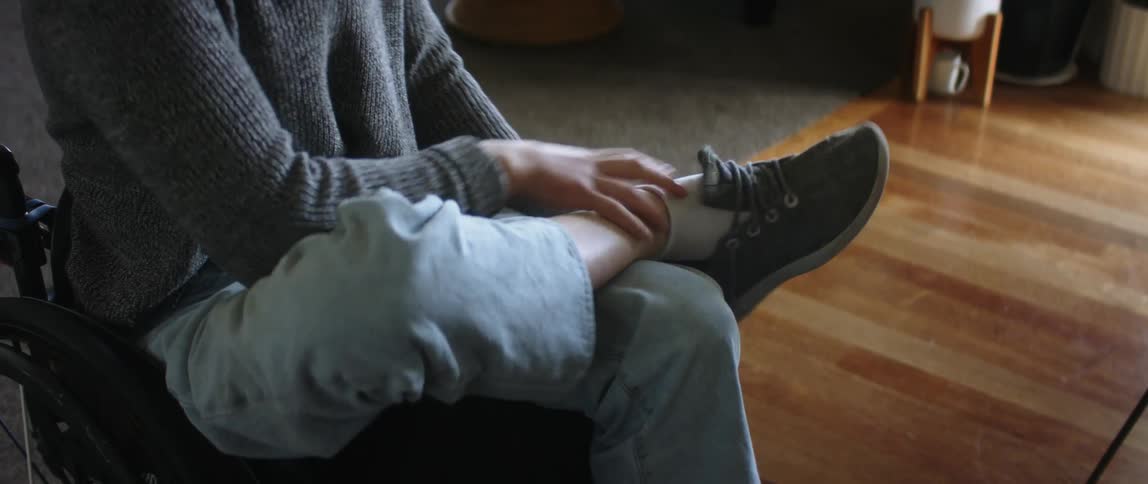 A woman is tying her shoes and sitting down