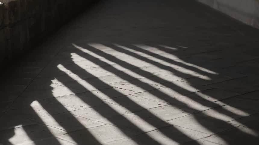 Columns cast shadows and light in a corridor