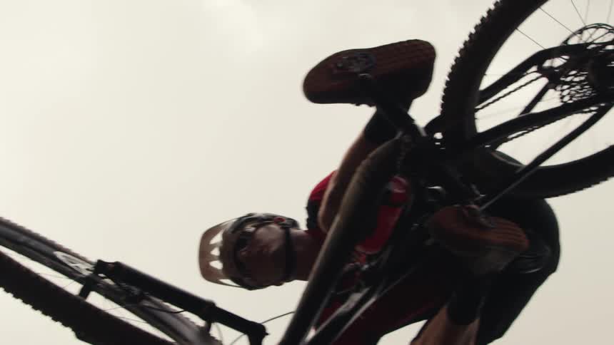 A teenage boy on a mountain bike is flying in the air as his feet are still on the pedals