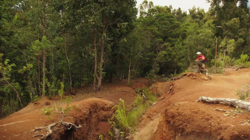 A cyclist jumps over a ravine while riding a bicycle offroad