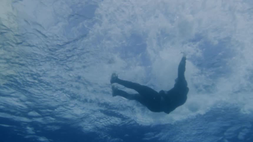 A person splashes in the water and sinks
