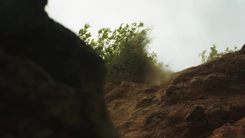 A man jumping down a hillside on his mountain bike